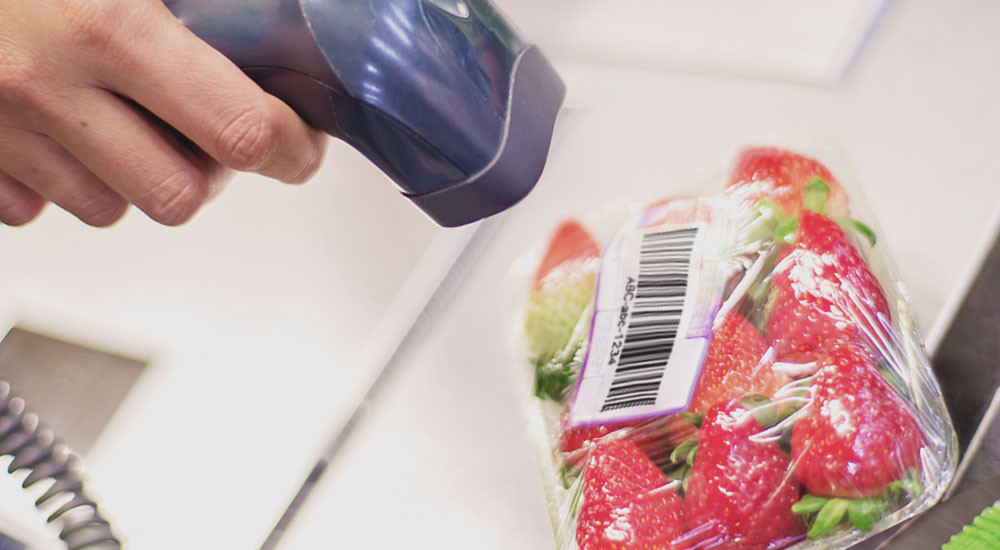 Retail worker scanning strawberry food barcode