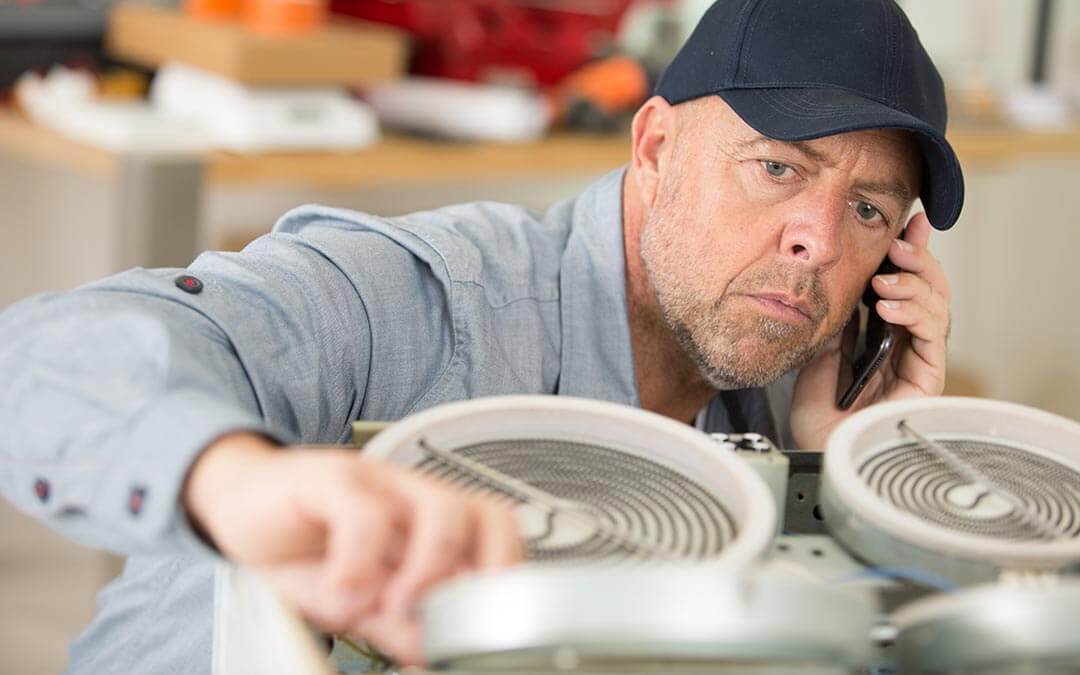 Field Technician on the phone inspecting a piece of machinery