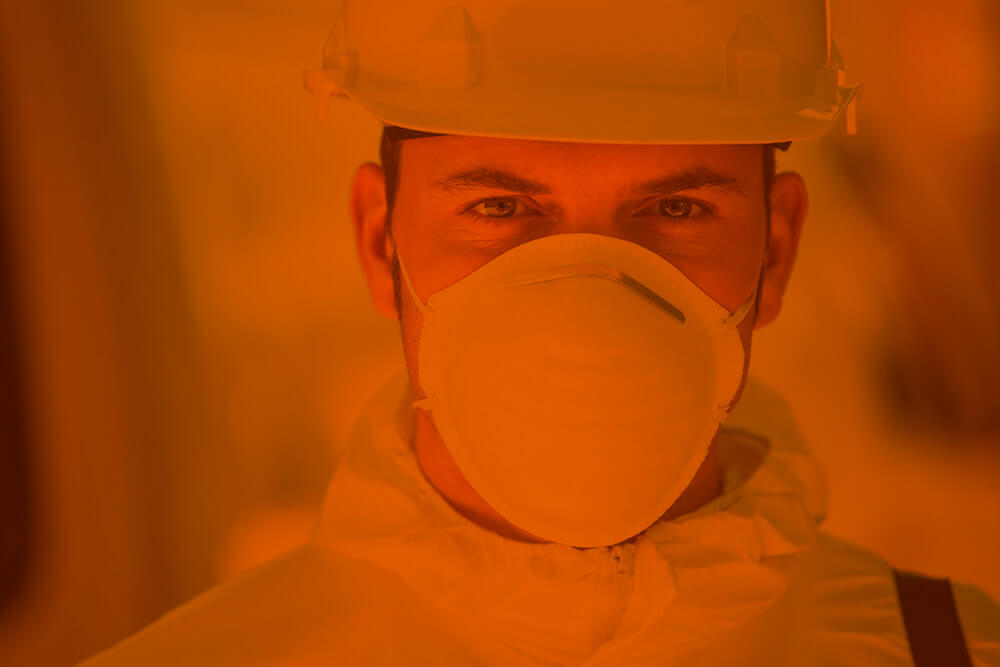 Close up of pest exterminator wearing a mask and hard hat