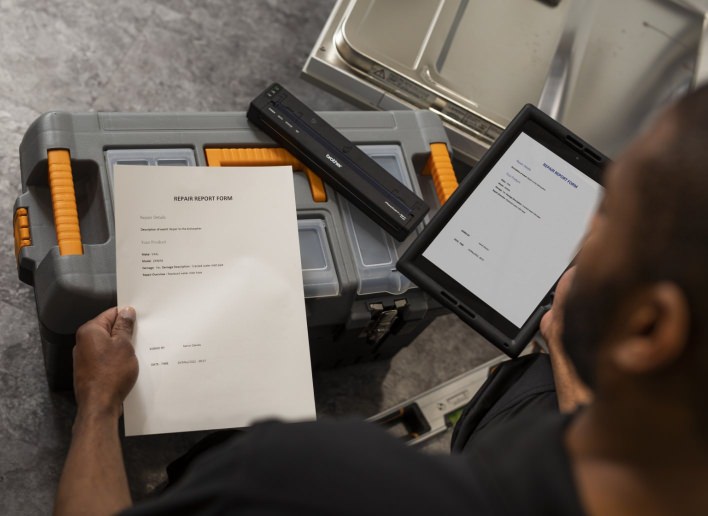 Field Service Technician Looking at Repair Form