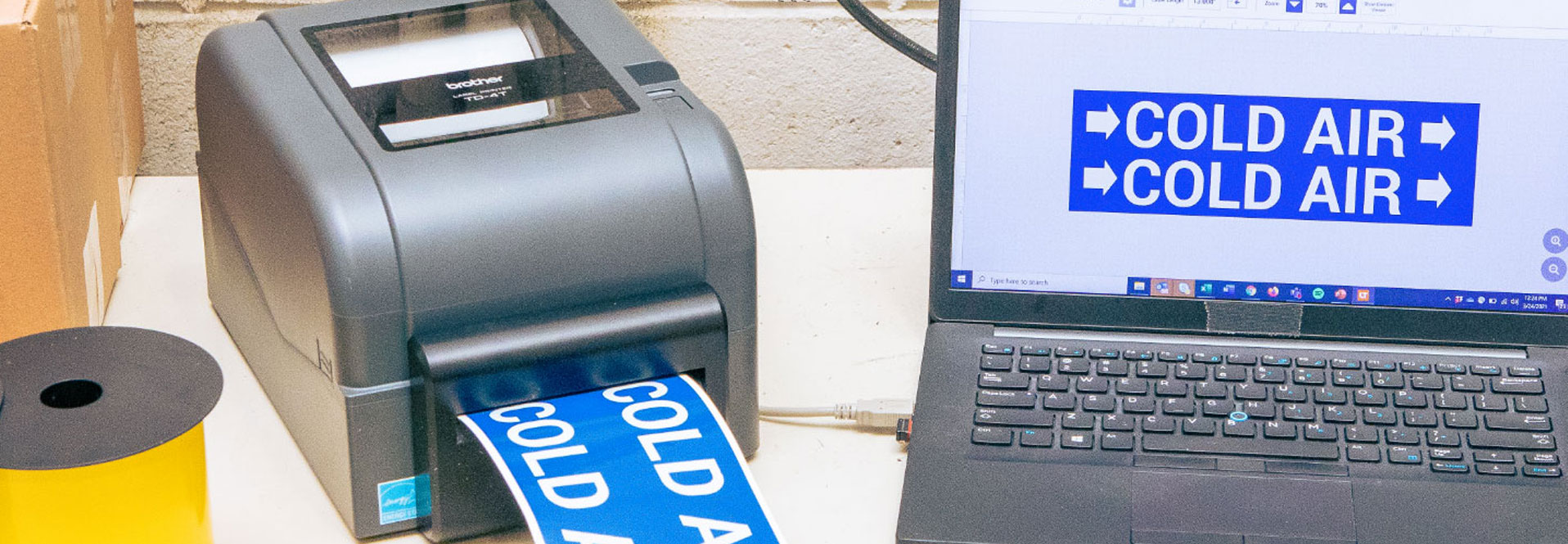 Brother TD Printer Sitting on Desk with Computer Printing Cold Air Label