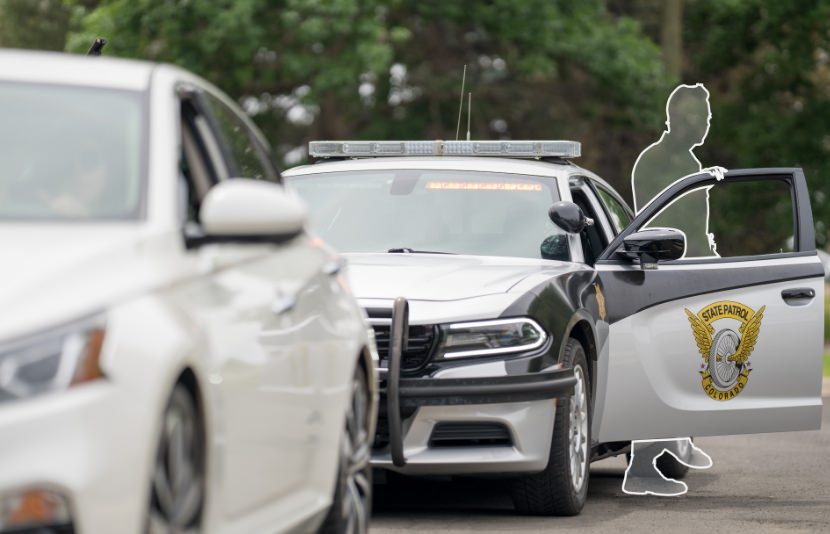 Outline of a police officer standing outside their vehicle during a traffic stop