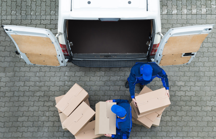 two people load van with shipping boxes