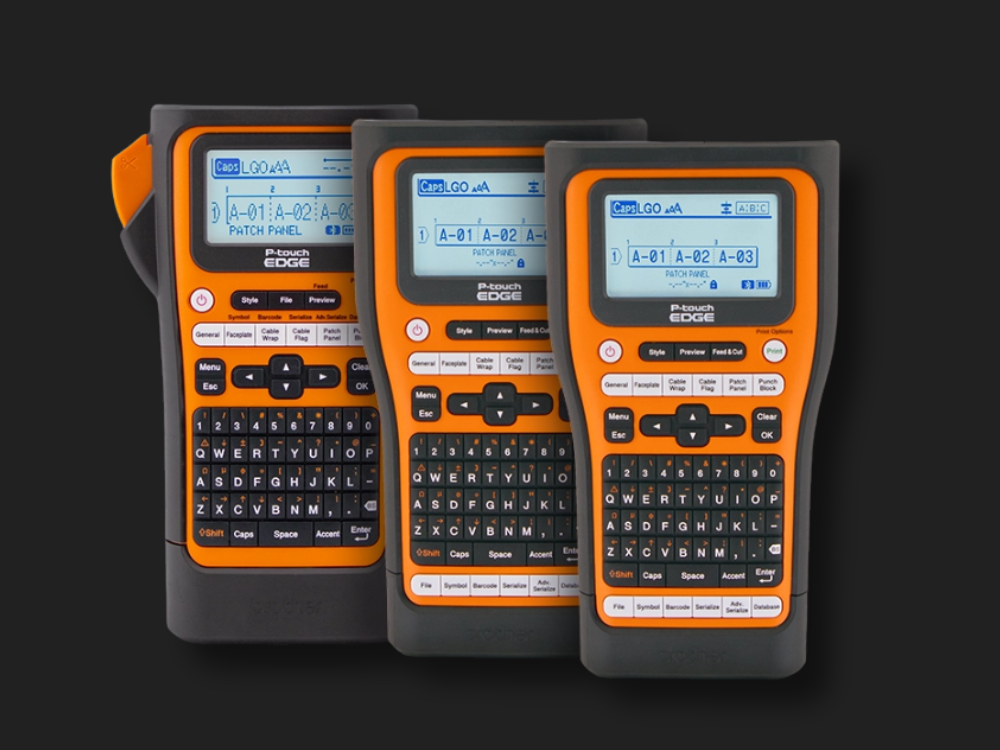 Three orange and black handheld label makers with screens and full QWERTY keyboards are displayed on a black background—perfect for your next tool promotion or landing page. Each device is ready to help you create crisp, clear tape labels in seconds.