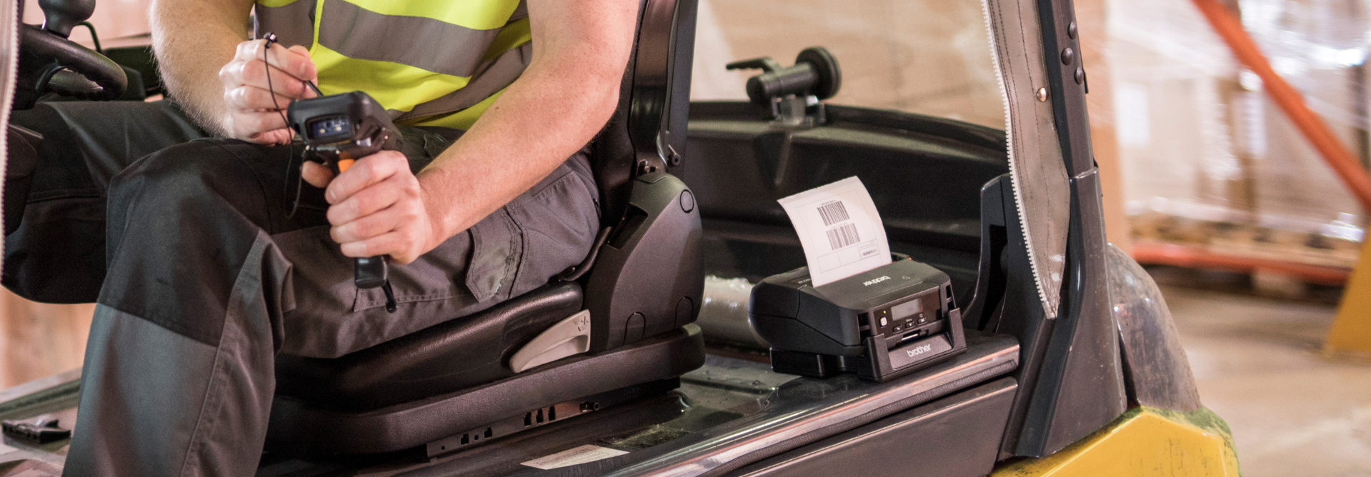 A worker scans a barcode with a handheld scanner beside a RuggedJet 4255WB-LCP wireless portable label printer inside a forklift.
