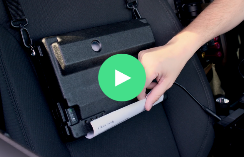A hand unlocks a black lockbox on a car seat with a keypad, revealing a roll of white paper from a PocketJet 8 printer—essential for handling documents during the warrant process or at a DUI checkpoint.
