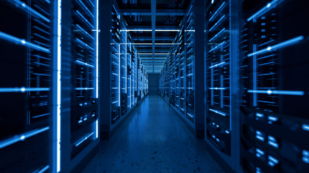 A hallway of server racks glows with blue LED lights in a modern data center, reflecting the latest labeling standards designed to meet growing AI demands.